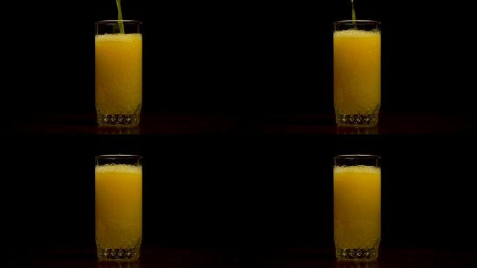 橙色苏打大玻璃，满溢的橙色苏打特写玻璃与气泡隔离在黑色背景。将橙色汽水倒入玻璃杯中