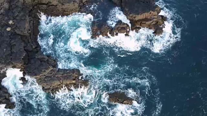 4k无人机拍摄的海浪溅到火山岩上