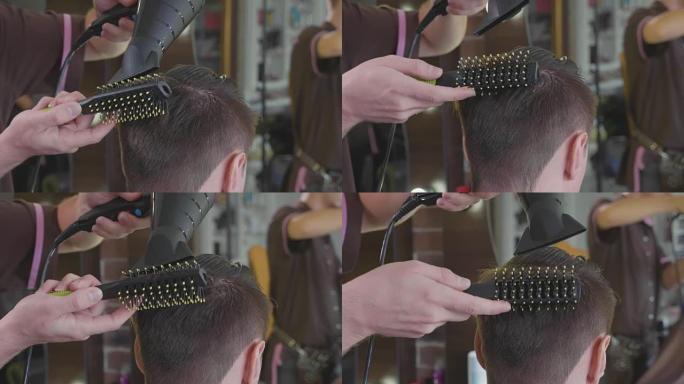 理发师在理发店为男性顾客制作梳子和吹风机发型。