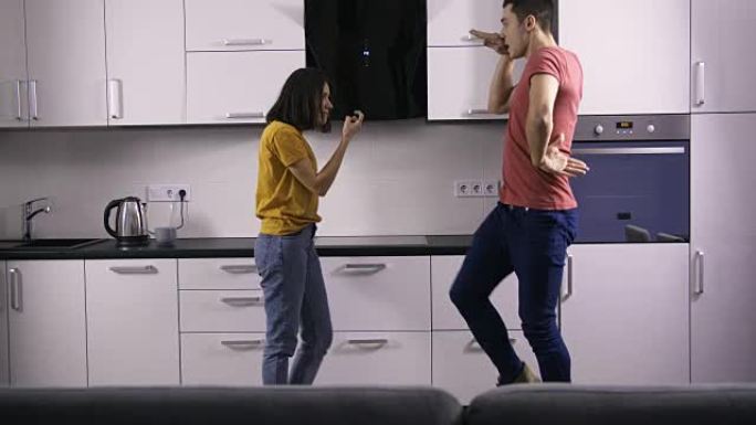 年轻的创意夫妇在厨房里的舞蹈动作