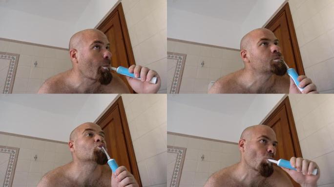 口腔卫生: 男人用电动牙刷刷牙