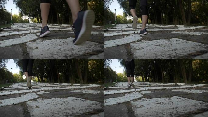 有魅力的瘦骨嶙峋的女孩与健美的腿部肌肉在一个白色的小巷公园慢跑上楼梯的慢镜头