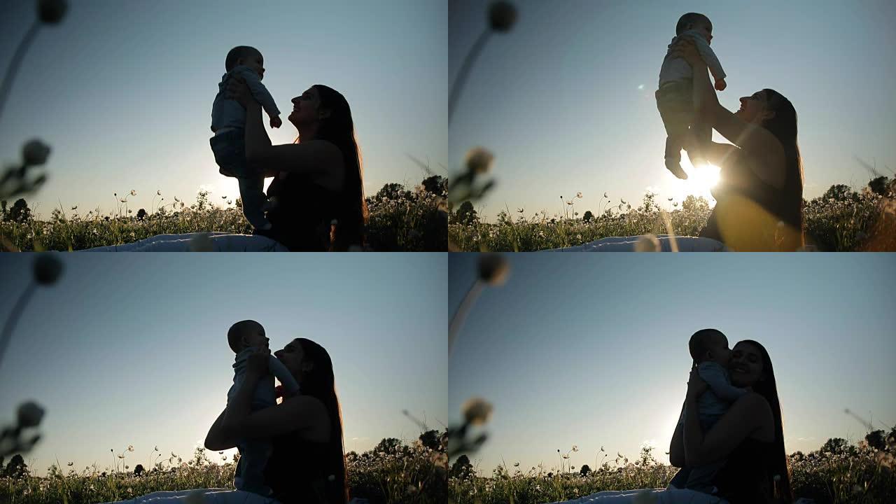 日落时分，一个年轻快乐的母亲和孩子在花田里的慢动作。