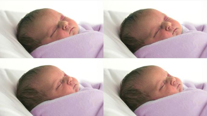 婴儿穿着粉红色的毯子睡得很香