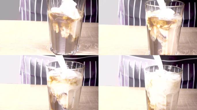 牛奶倒入一杯加冰的咖啡中
