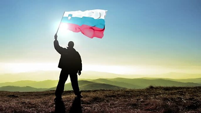 成功剪影男子冠军挥舞斯洛文尼亚国旗山顶上，Cinemagraph循环背景