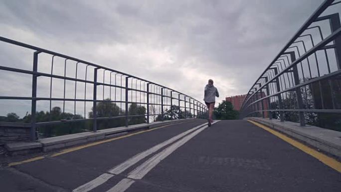 女孩在城市公园的桥上奔跑