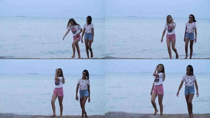 两个时尚青少年女友晚上在海滩散步