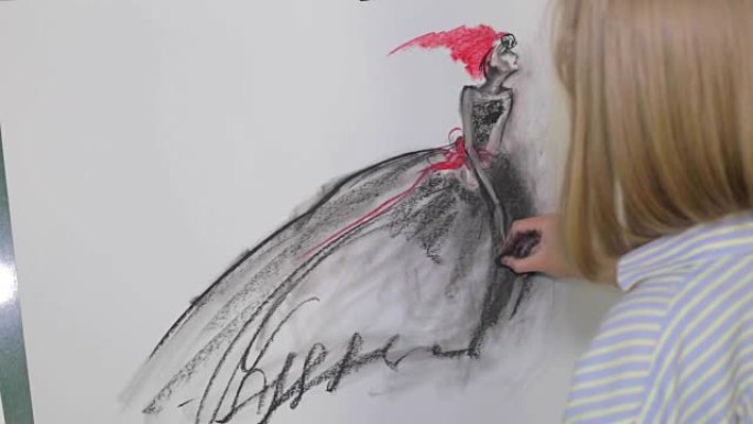 女艺术家用煤在画布上画一个女人。画布立在画架上。绘图过程