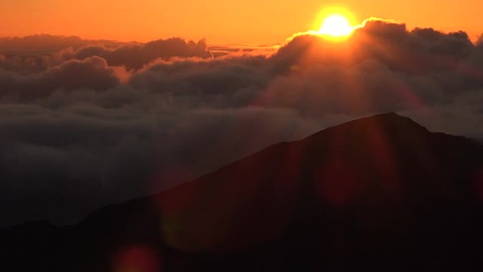 太阳冲过茂宜岛山顶的云层