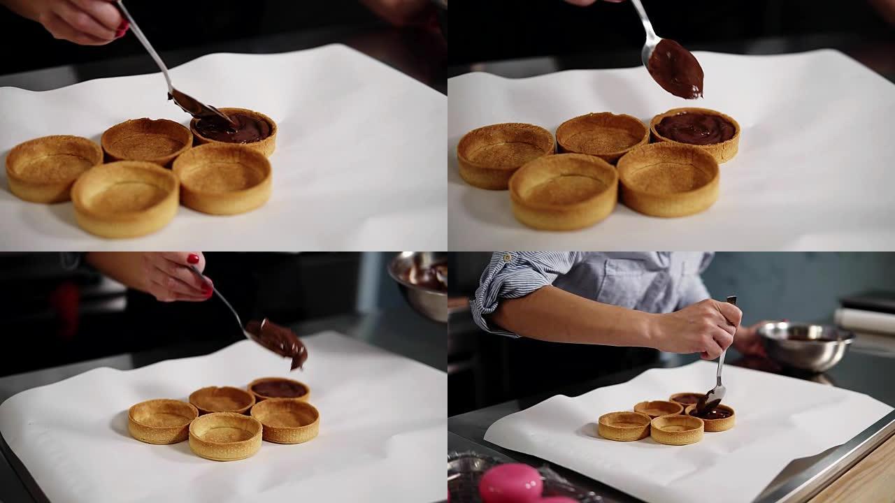 用勺子用巧克力奶油填充烤馅饼的过程结束。用白纸覆盖的工作台