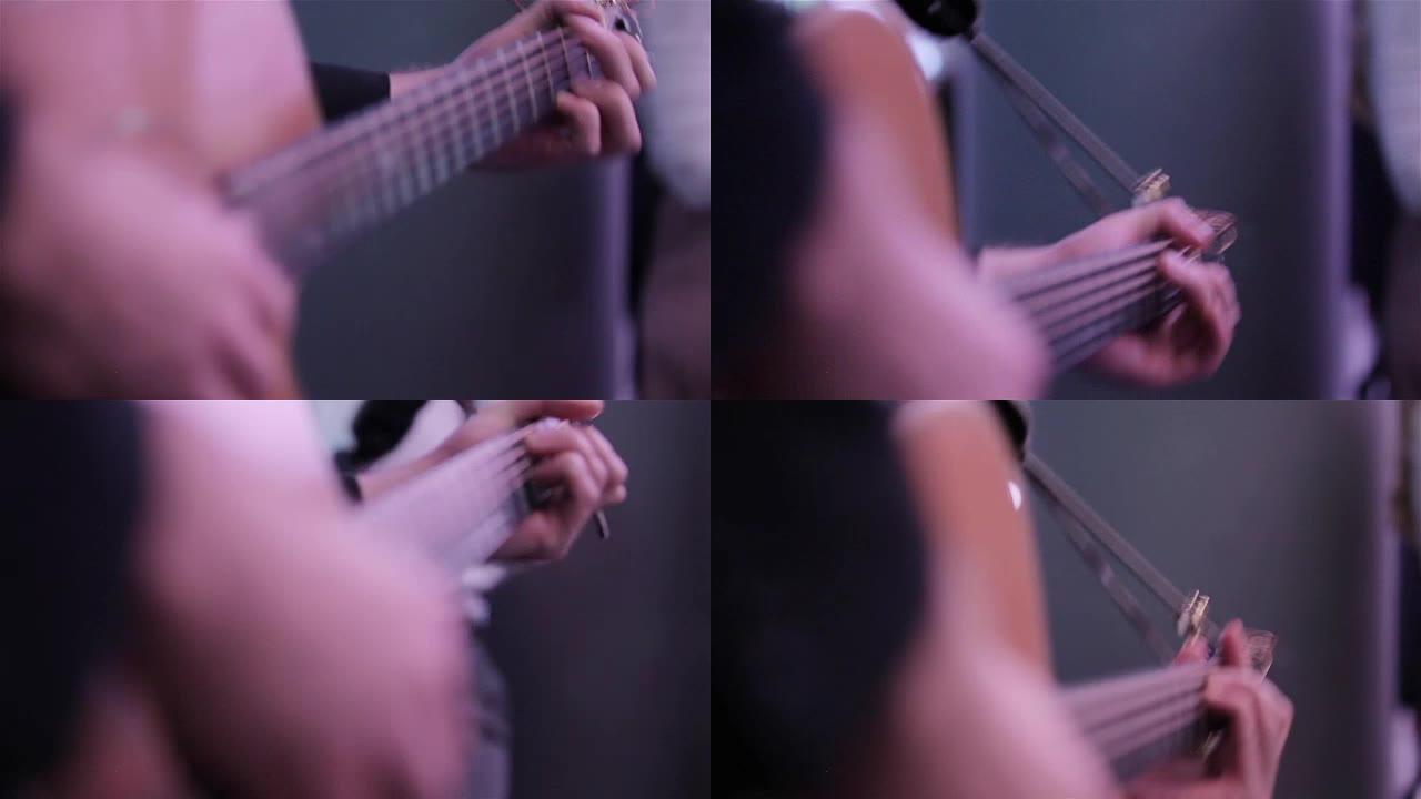 手弹奏原声吉他手指按压指板上的和弦关闭宏机架焦点。音乐家在喜剧俱乐部活动中表演乡村歌曲拨弦，摄影师在