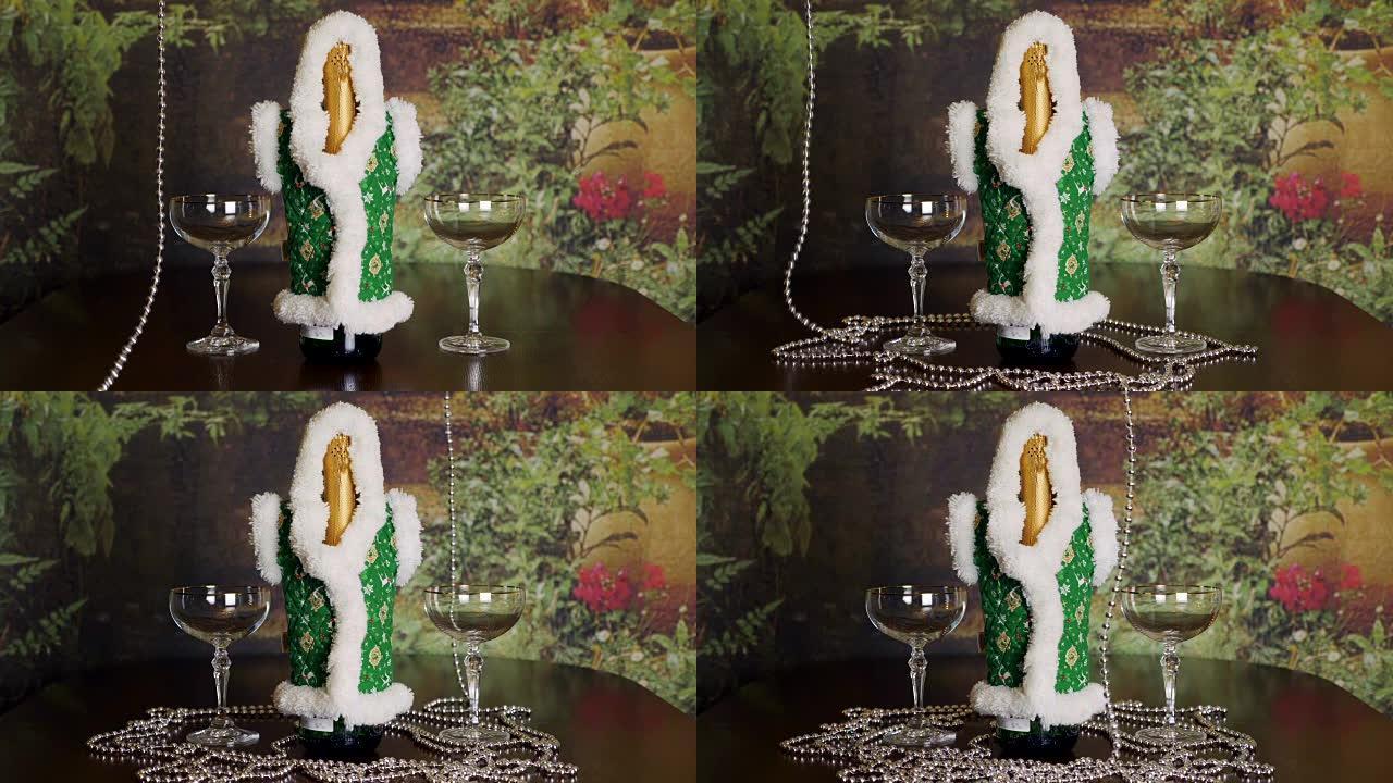 寒假的概念。圣诞新年背景。一瓶香槟和一对酒杯放在室内的桌子上。瓶子上的手敷料外套。桌子上放着长长的银