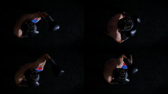 年轻的高加索人上身拳击手在防护头盔，戳刺，拳，黑色背景，顶视图50 fps