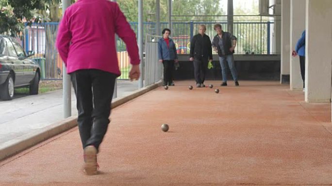 高级女子在Petanque练习中扔球