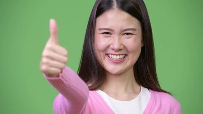 年轻美丽的亚洲女人竖起大拇指