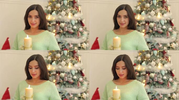 在圣诞树旁手拿蜡烛的女孩。