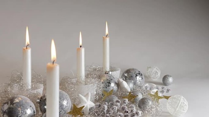 节日装饰中的四个银色烛光，带有闪光球和稀疏的天使头发