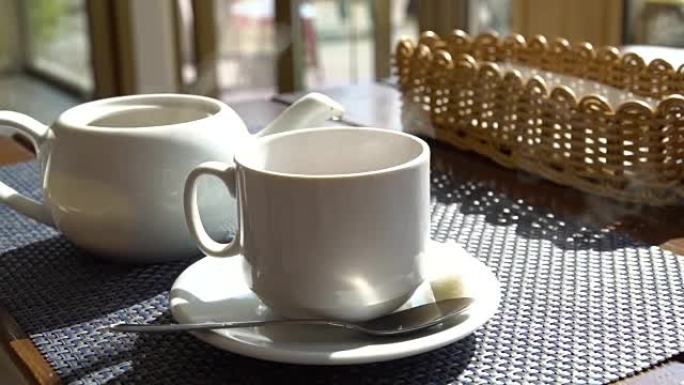 咖啡馆桌上热气腾腾的白杯茶咖啡。热饮料