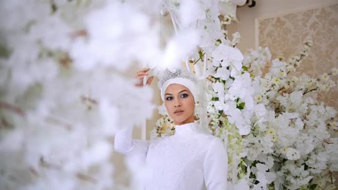 穿着白色婚纱和新娘头饰的美丽穆斯林新娘