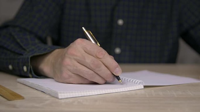 用钢笔在字帖里学习和写作的人。用钢笔把人的手记在笔记本上。