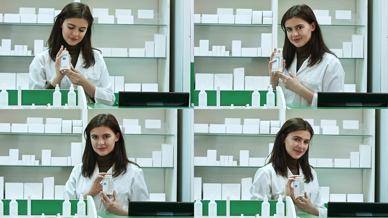 一位开朗的年轻女药剂师，拿着一瓶毒品站在药房药房里看着相机