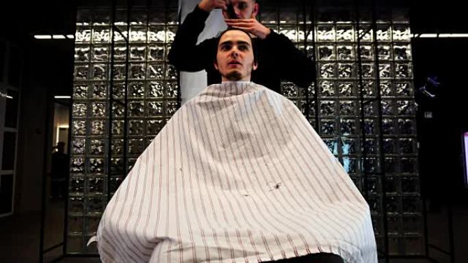 男美发师用剪刀剪发另一名男子的头发