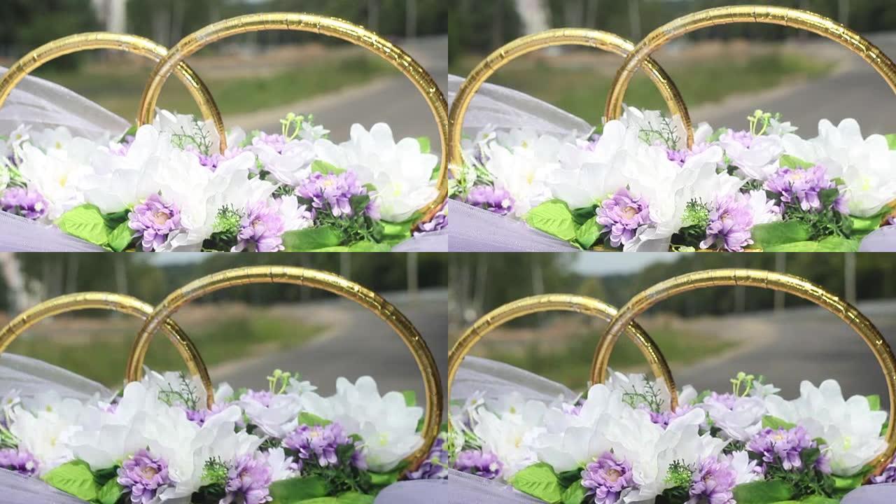 婚礼花束紫罗兰紫色的鲜花在骑乘车上吹拂，幸福的新婚夫妇
