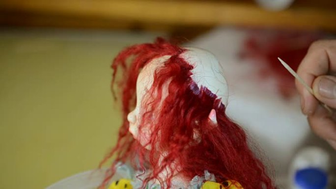 木偶大师把头发粘在人偶的头上。