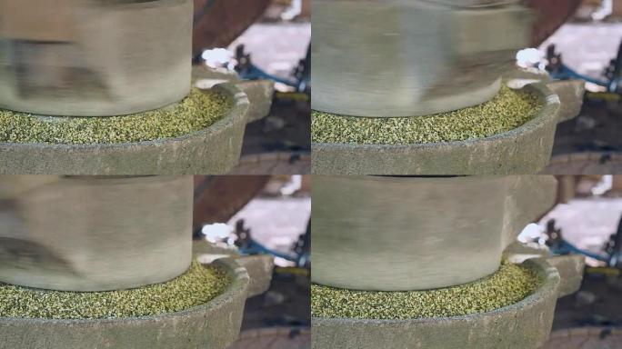 一个女人用手翻磨石磨绿豆的特写镜头