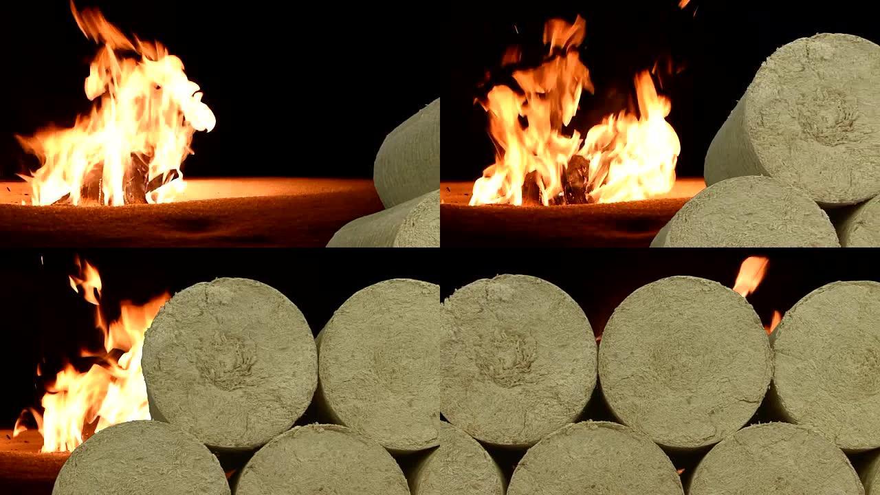 木制木屑煤球，冬天在雪地上燃烧的背景火。替代燃料，生物燃料。滑块镜头。