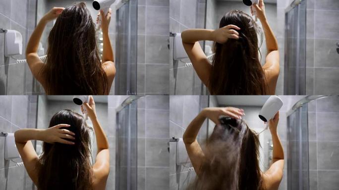 护发女孩手持电动吹风机，在酒店房间的浴室吹湿头发