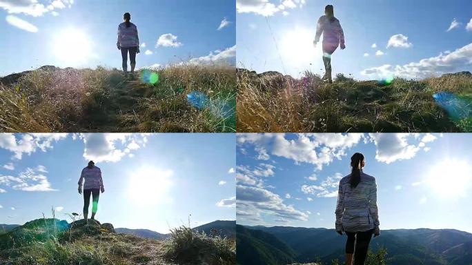 低角度的女人在山顶的日落徒步女孩庆祝生活风景自然景观享受假期旅行冒险