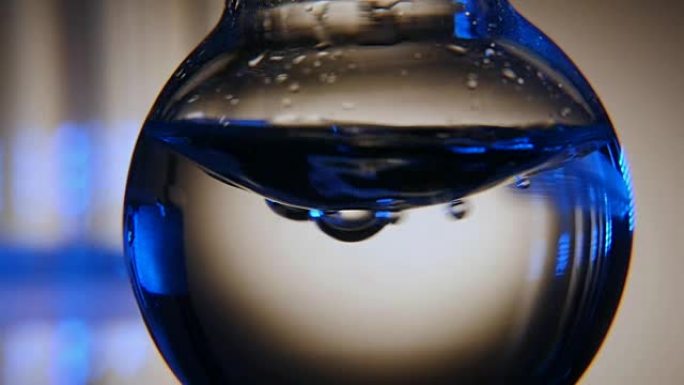 在化学实验室的圆底烧瓶中摇动蓝色水