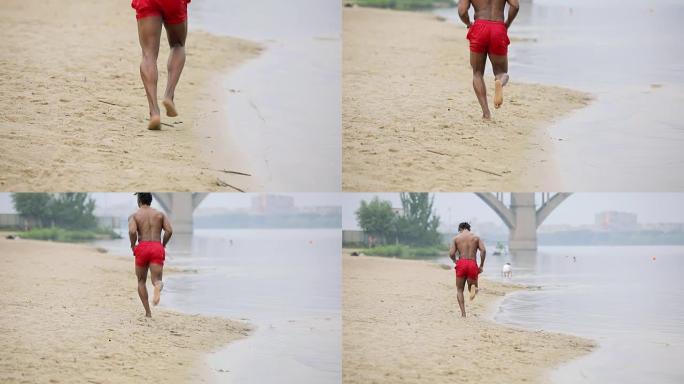 身体肌肉发达的男人在雨中在海滩上奔跑，后视图