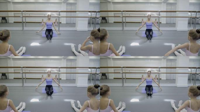 儿童芭蕾舞团的老师展示了女孩的脚尖练习