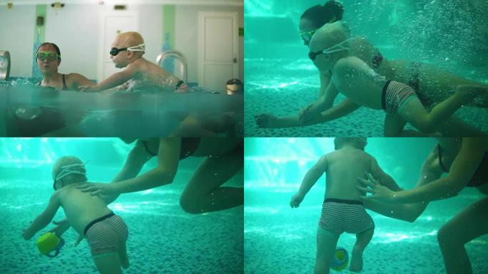 戴着防护眼镜的可爱的金发蹒跚学步的孩子和他的母亲一起在游泳池里潜水，试图拿出他的玩具。他妈妈在教他游