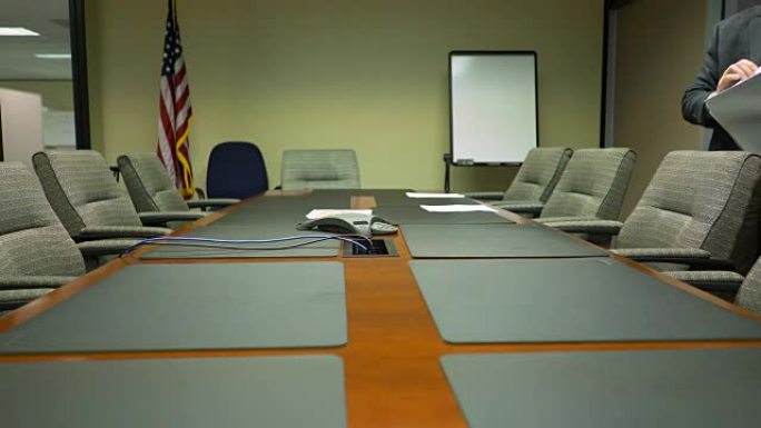 商人将纸张放在公司董事会会议室的桌子上开会