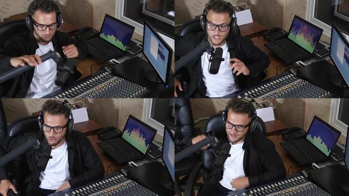 耳机里的DJ坐在调音台旁边，在背景电脑屏幕上对着迈克说