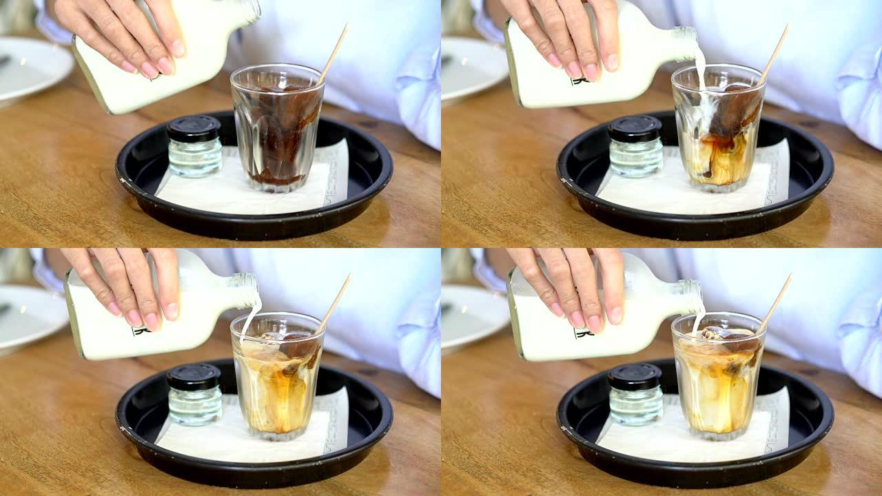 女人将牛奶倒入玻璃咖啡冰立方中。