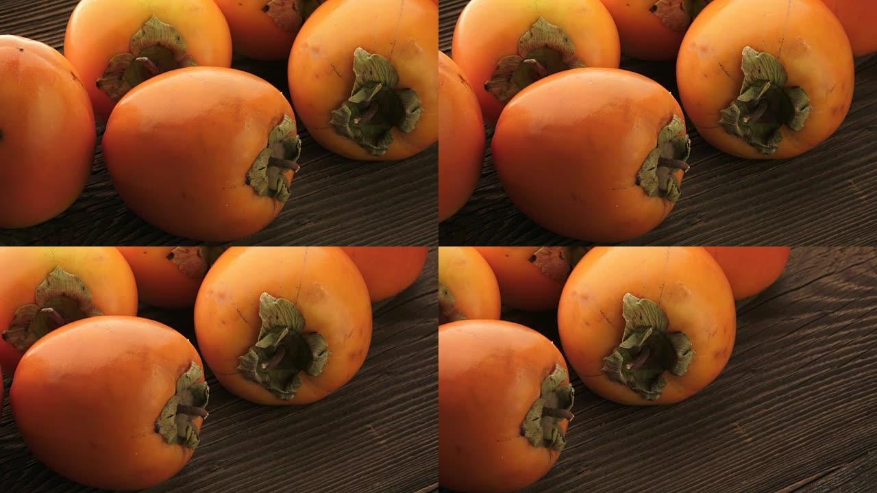 木制桌子上的新鲜橙色柿子。美味的橙色柿子。