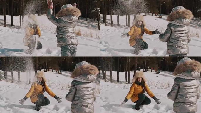 母亲在慢动作中与小女儿玩雪