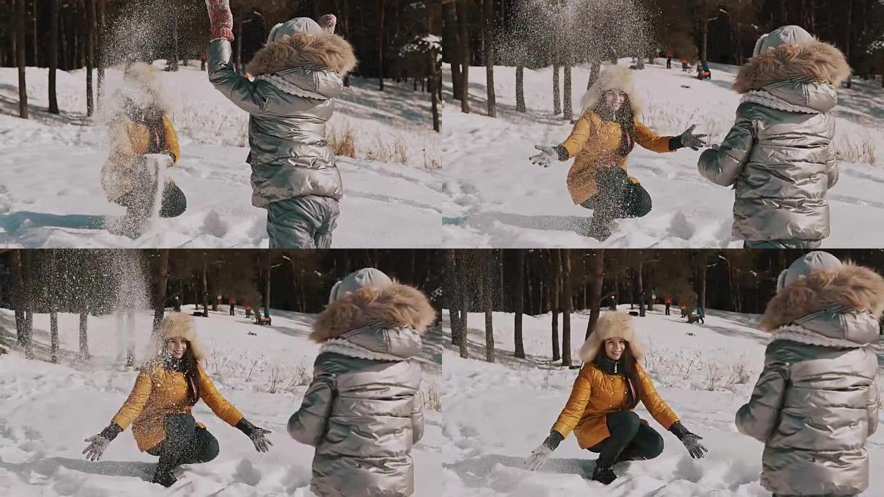 母亲在慢动作中与小女儿玩雪