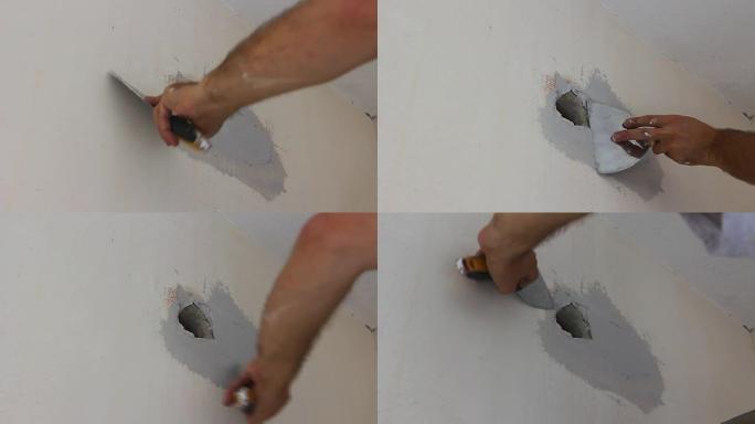 工人在油漆前在墙壁插座周围涂上脱脂涂层材料