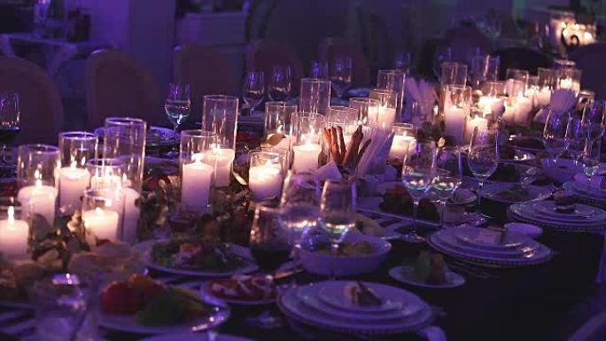 餐桌上的装饰蜡烛，餐桌上的眼镜和圣诞节蜡烛，带玻璃烛台的白蜡烛台，带玻璃烛台的蜡烛，餐厅，室内，特写