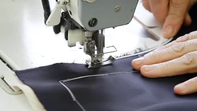 女裁缝用机器缝制一件藏青色的夹克