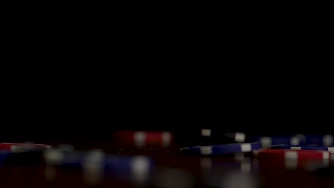 孤注一掷的筹码落在黑色上。在黑色背景的扑克桌上玩筹码飞舞的游戏。薯片在派对背景上飞舞。赌场的概念