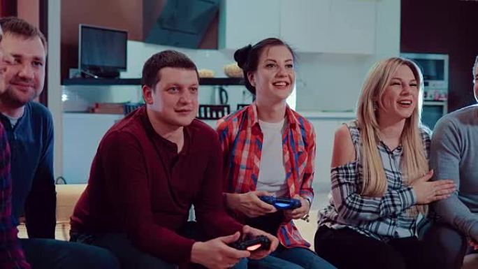 恋爱中的快乐夫妇人们喜欢用无线控制器玩电子游戏放松，在现代公寓里玩室内玩乐