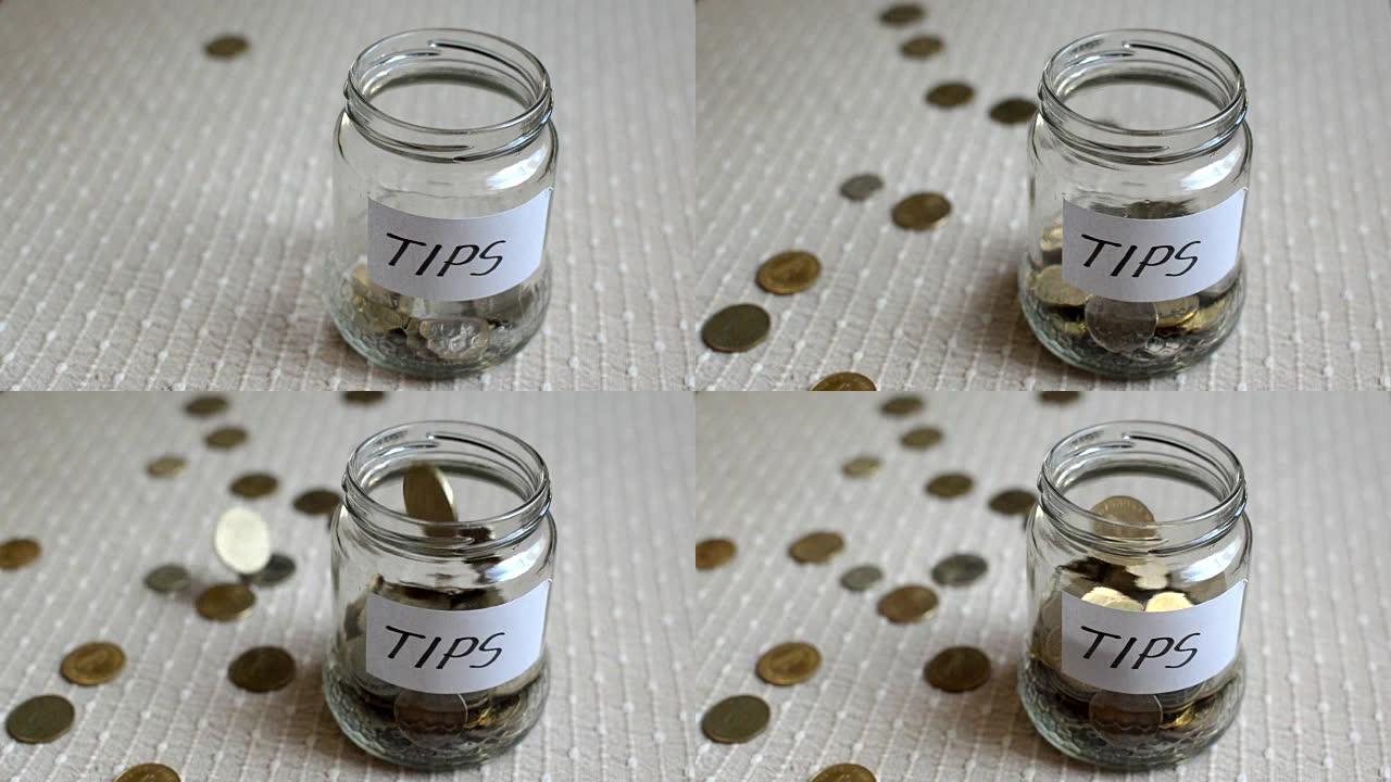 硬币填充并溢出一个标有提示的透明中型玻璃罐