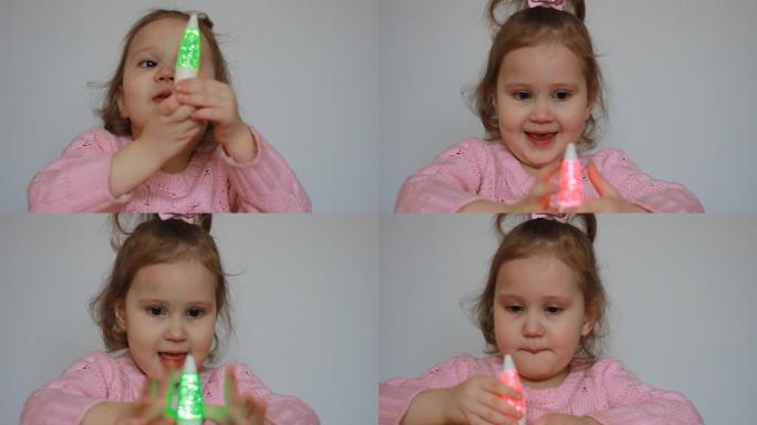 一个可爱的孩子用手电筒玩耍，看着它发出的五彩光芒。拿着灯笼的漂亮女孩。